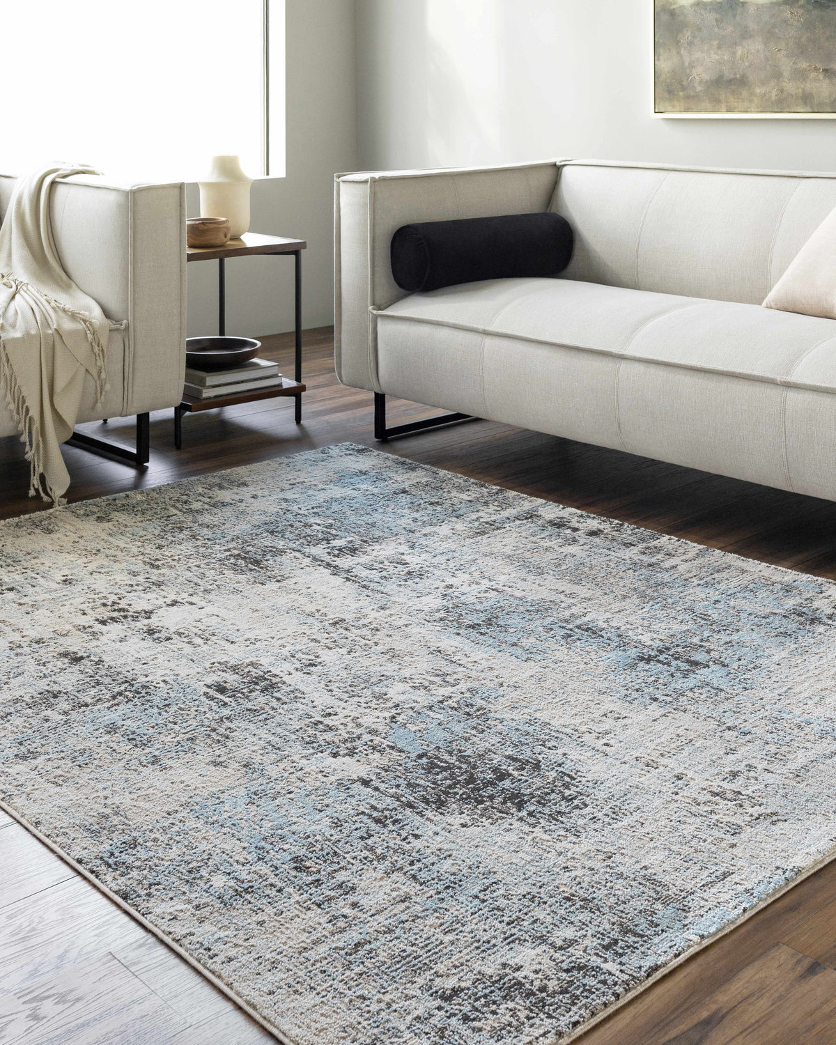 Living room scene with a Vesna Blue Area Rug, light sofa, dark wood floors, and neutral decor. Roomscene-Rectangle