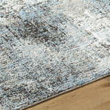 Close-up of the Vesna Blue Area Rug showing its charcoal, ivory, and blue Southwestern design and soft texture. Texture