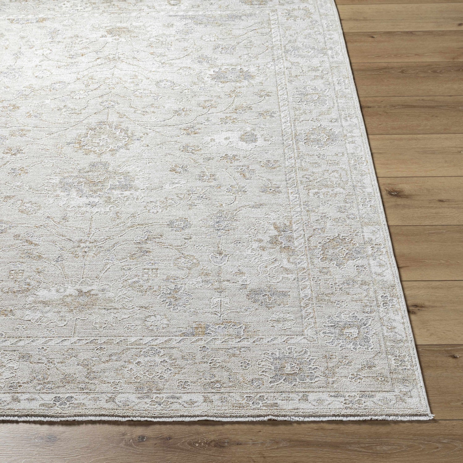 Close up of the light silver Vaman Luxe Rug showing its traditional floral pattern and texture. Front