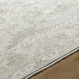 Close-up of the Vaman Luxe Rug. Light silver and sterling gray tones with a traditional, subtle floral pattern. Machine woven texture. Texture