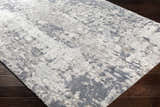 Close-up of the Walhonding Area Rug, a contemporary rug in denim, ivory, and gray, with a soft, textured pile. Corner