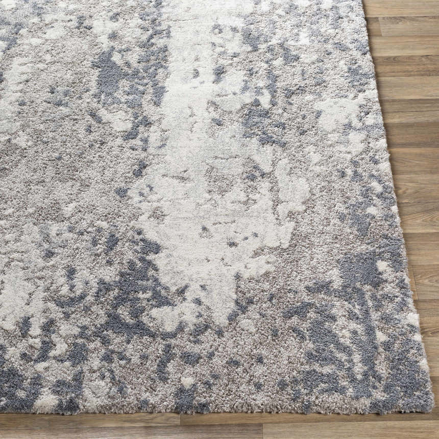 Close-up of the Walhonding Area Rug, a contemporary rug in denim, ivory, light gray, and medium gray on wood flooring. Front