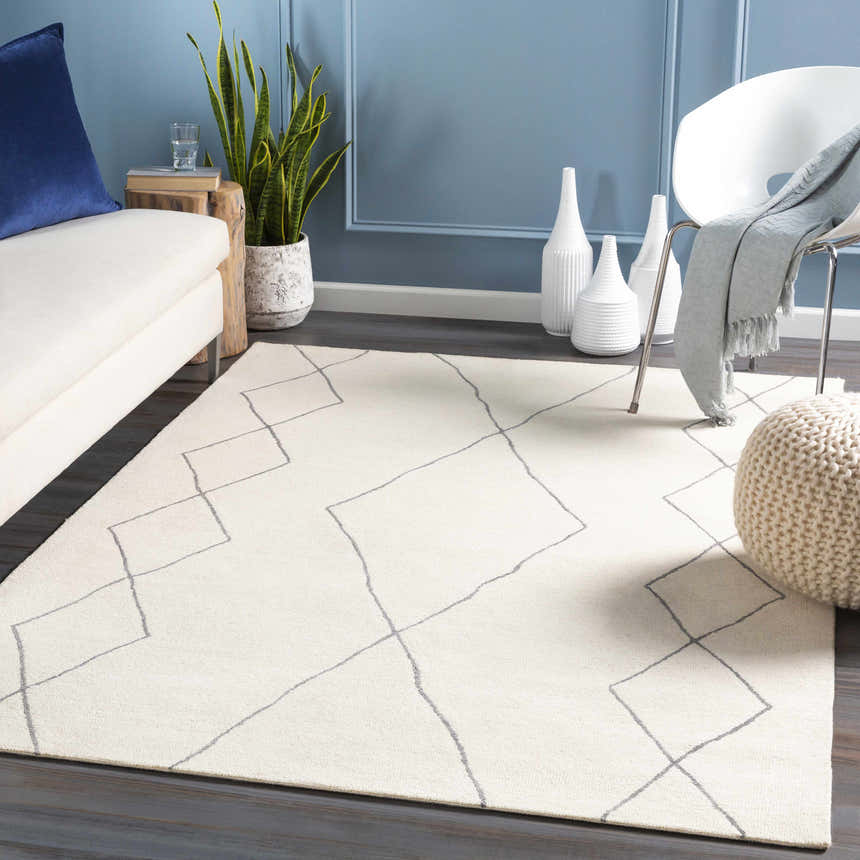 Living room scene with a cream sofa, white chair, and the Warbranch Area Rug in charcoal and cream. Roomscene-Rectangle