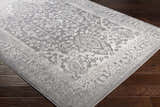 Close-up of the Watford Updated Traditional Tibetan Rug. Gray and ivory floral pattern on a charcoal background. Corner