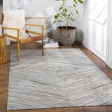 Modern room scene with Wauzeka Premium Area Rug, wood chair, plant, and natural light. Roomscene-Rectangle