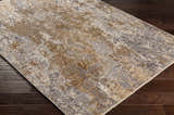 Close-up of the Woodmoor Area Rug showing its bone, dark gray, and walnut abstract pattern and machine woven texture. Corner