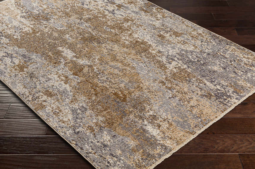Close-up of the Woodmoor Area Rug showing its bone, dark gray, and walnut abstract pattern and machine woven texture. Corner