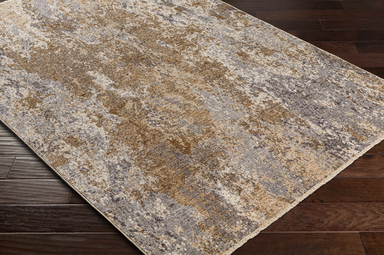 Close-up of the Woodmoor Area Rug showing its bone, dark gray, and walnut abstract pattern and machine woven texture. Corner
