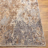 Close up of the Woodmoor Area Rug showing bone, dark gray, and walnut colors on a wood floor. Front