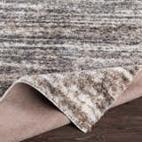 Close-up of the Weddin Striped Plush Area Rug. Charcoal, cream, gray, and tan stripes. Plush texture. Fold