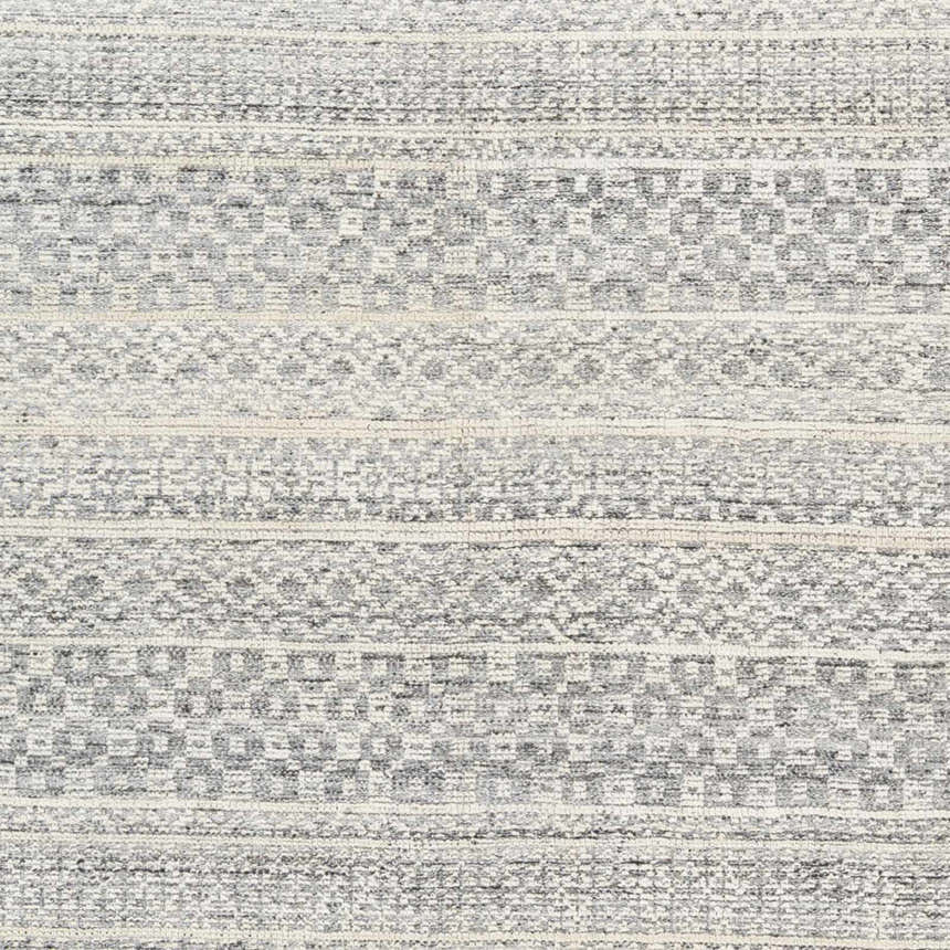 Close-up of Wessington Area Rug. Hand-knotted wool rug with cream, light gray, and medium gray bohemian pattern. Texture