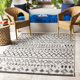 Outdoor patio scene with wicker chairs and black and white Westside Outdoor Area Rug. Roomscene-Rectangle