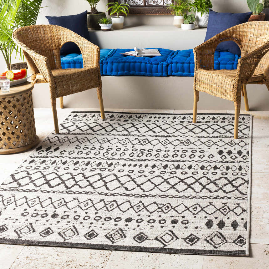 Outdoor patio scene with wicker chairs and black and white Westside Outdoor Area Rug. Roomscene-Rectangle