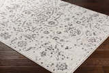 Close up of Willowbrook Area Rug in charcoal, gray, light beige, and medium gray with a vintage, oriental-inspired pattern. Corner