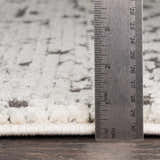 Close-up of the pile height of the Willowbrook Area Rug, showing charcoal and light beige tones. Pile