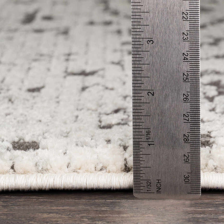Close-up of the pile height of the Willowbrook Area Rug, showing charcoal and light beige tones. Pile