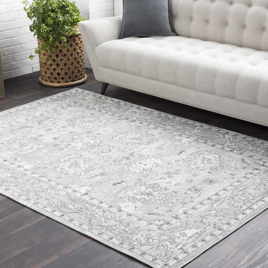 Living room scene with a light sofa and gray Winstonville Clearance Rug on dark wood floor. Roomscene-Rectangle