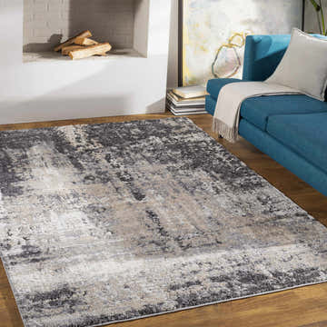 Living room scene with a Witchford Abstract Charcoal Thick Rug, blue sofa, fireplace, and wood floors. Roomscene-Rectangle