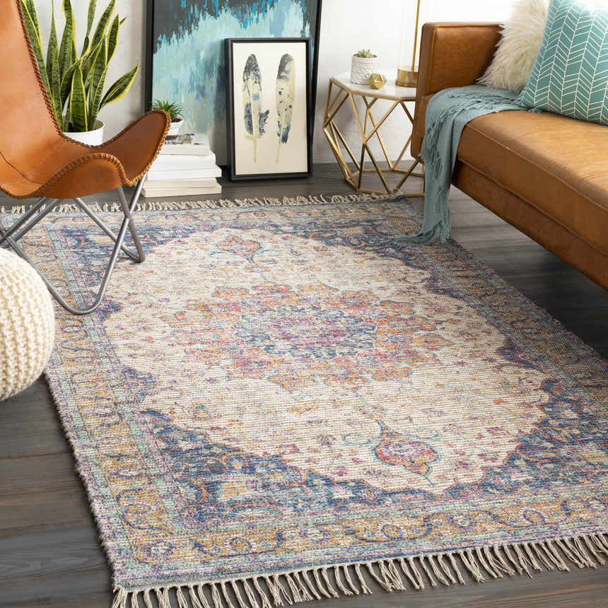 Living room with leather sofa and Wallburg Hand Woven Colorful Tassel Rug in light blue, purple, tan, white, and yellow. Roomscene-Rectangle