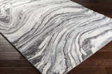 Close-up of the Walloon Gray Marble Thick Rug showing its charcoal, gray, and ivory swirling pattern and texture. Corner
