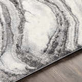 Close-up of the Walloon Gray Marble Thick Rug, showing its charcoal, gray, and ivory swirling marble pattern and textured weave. Texture