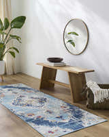 Entryway with a light wood bench, round mirror, and blue Wallsburg runner rug on wood floor. Roomscene-Runner