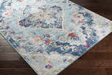 Close-up of the Wallsburg Blue Area Rug showing its bohemian floral pattern and colors like blue, orange, fuchsia, and gray. Corner