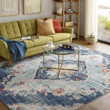 Living room scene with a Wallsburg Blue Area Rug, green sofa, and gold coffee table. Bohemian style. Roomscene-Rectangle