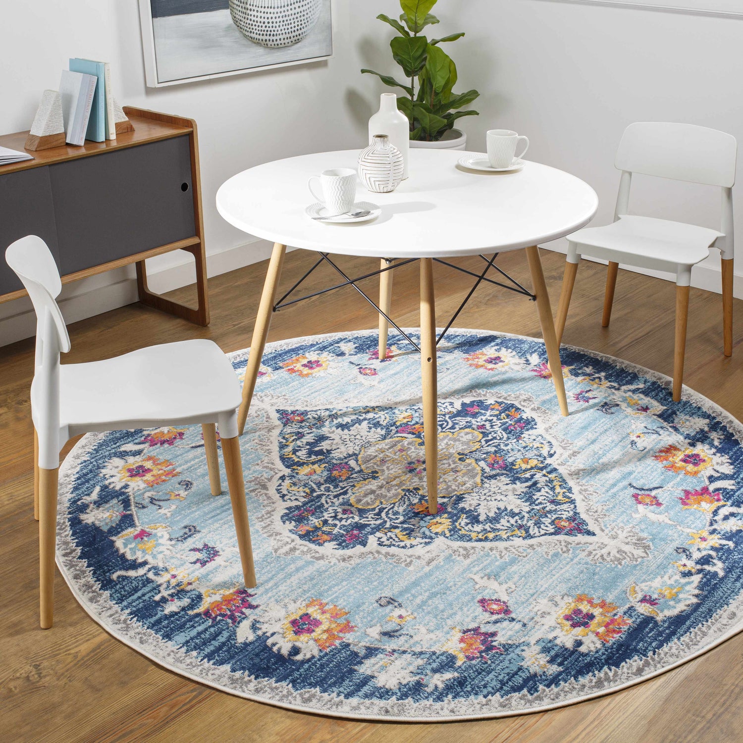 Dining room scene with round Wallsburg Blue Area Rug under a white table and chairs. Roomscene-Round