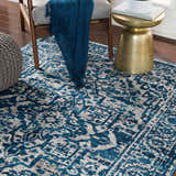 Living room scene with blue and gray Wellsblue Traditional Rug, chair, and gold accent table. Roomscene-Rectangle