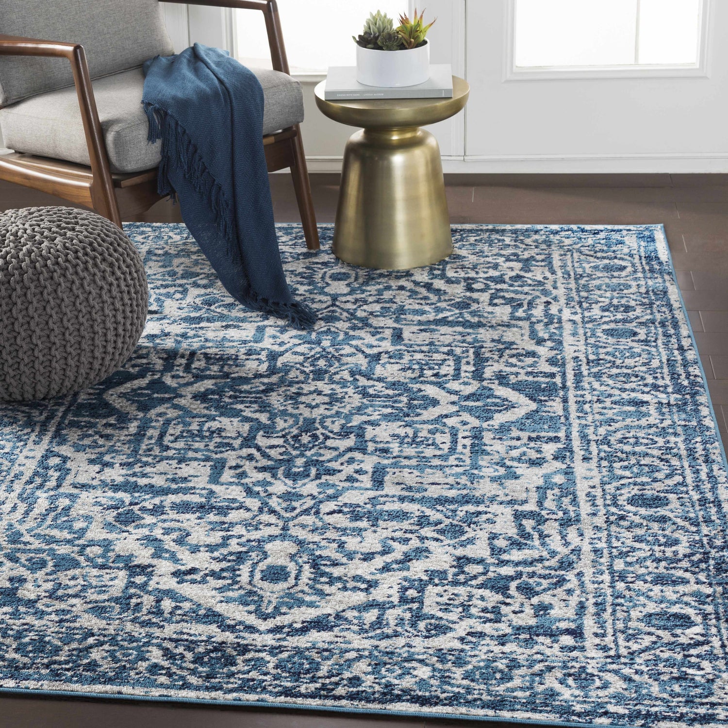 Living room scene with a blue and white Wellsblue Traditional Rug, gray chair, and brass side table. Roomscene-Rectangle
