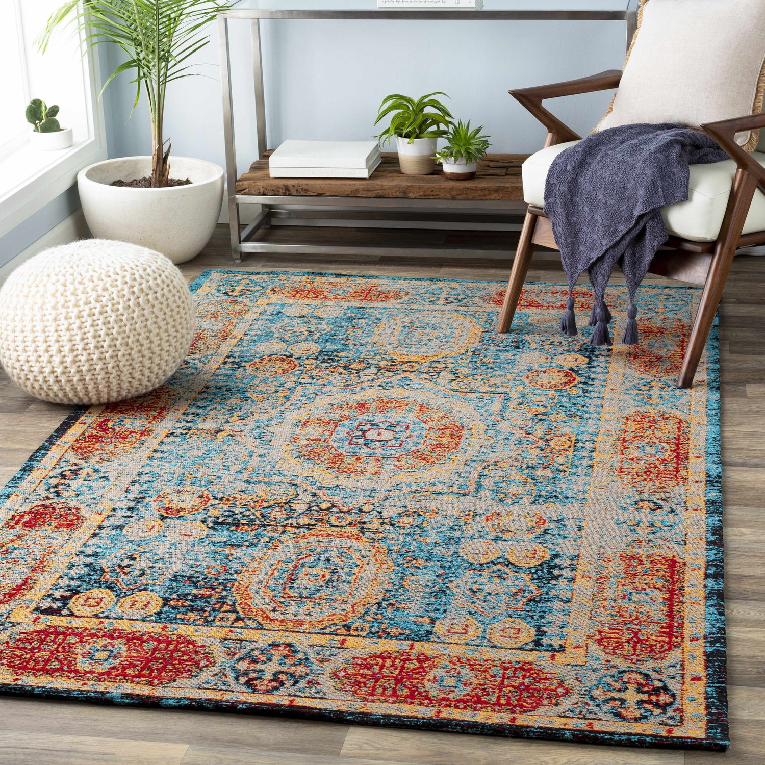 Living room scene with Wrangell Blue/Red Damask Carpet, wood chair, and knitted pouf. Bohemian, vintage style. Roomscene-Rectangle