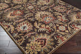 Close-up of the hand-tufted Chesterton 1028 brown wool rug. Features a traditional floral pattern in brown, red, beige, and sage. Corner