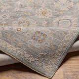 Close-up of the Wurtulla Thick Luxe Statement Rug, showing its light beige, gray, and denim traditional floral pattern and texture. Fold