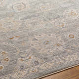 Close-up of the Wurtulla Thick Luxe Statement Rug. Features a traditional, vintage pattern in dusty sage, beige, and brown tones. Texture