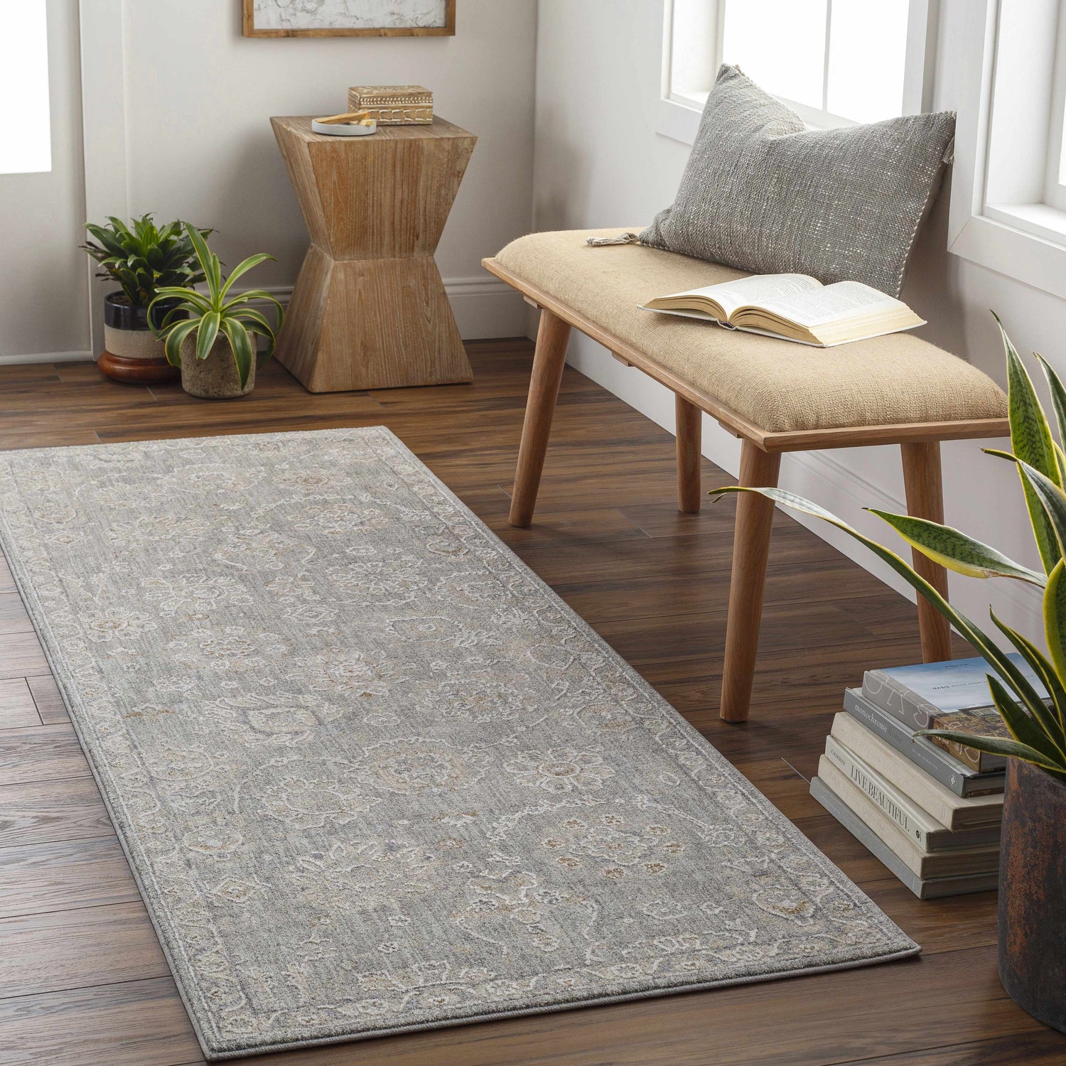 Entryway scene with a gray Wurtulla Thick Luxe Statement Rug, wooden bench, plants, and hardwood floors. Roomscene-Runner