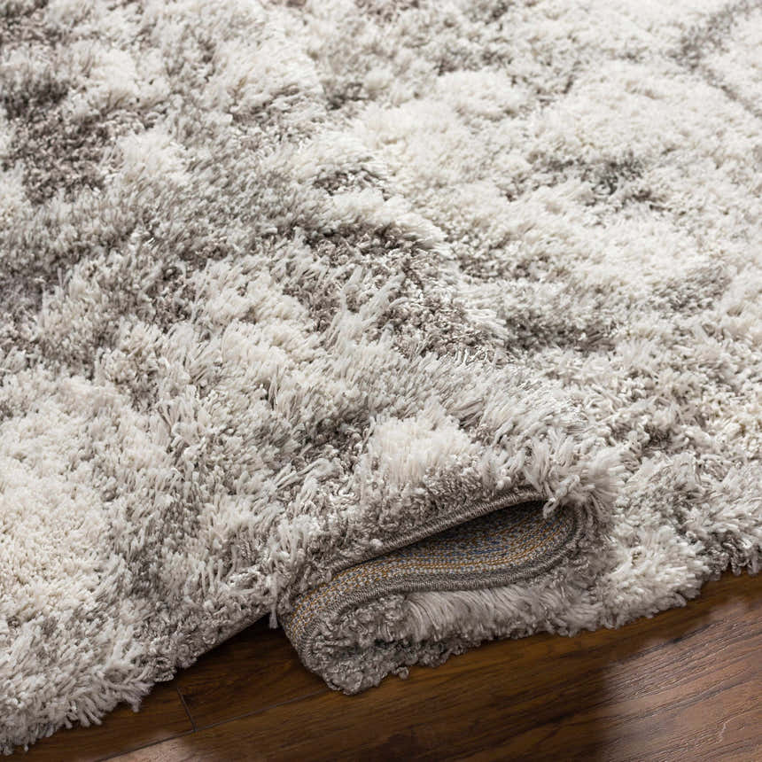 Close-up of the plush Wynant Gray Tones Rug, showing its soft texture, light gray, medium gray, and off-white colors. Fold