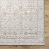 Close-up of the Xipil Area Rug. Traditional vintage design in dark red, ivory, olive, and pale blue. Corner