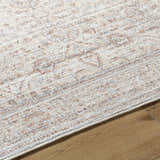 Close-up of the Xipil Area Rug showing its traditional vintage design, ivory base, and dark red, olive, and peach accents. Texture