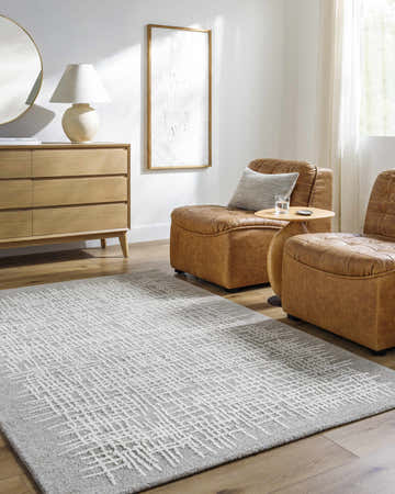 Living room scene with ash Uhuti Area Rug, brown leather chairs, and light wood dresser. Roomscene-Rectangle