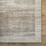 Close-up of the Xandy Thick Luxe Rug. Beige, light gray, and tan hues create a contemporary, textured pattern. Corner
