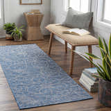 Entryway with blue Yackandandah Flatweave Area Carpet runner, wood bench, plants, and books for a cozy, coastal vibe. Roomscene-Runner