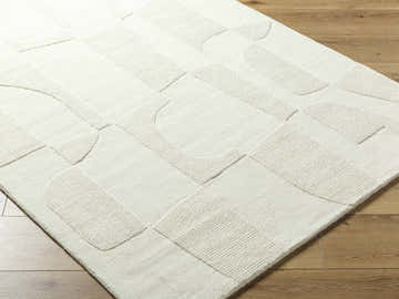 Close-up of the light silver Yaniv Area Rug, a hand-loomed wool rug with a contemporary geometric design. Corner
