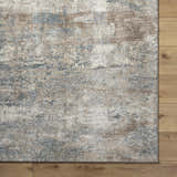 Close up of the Yoshe Thick Luxe Rug showing beige, gray, and tan hues with a contemporary pattern and soft texture. Corner