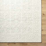 Close up of the hand-tufted Yadid Sage Wool Area Rug showing its texture and traditional light silver pattern. Swatch