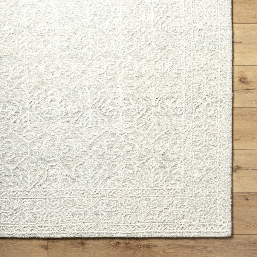 Close up of the hand-tufted Yadid Sage Wool Area Rug showing its texture and traditional light silver pattern. Swatch