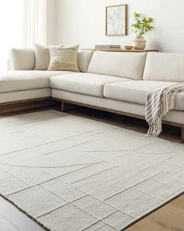 Living room scene with a light silver Yvian Area Rug, off-white sectional sofa, and wood accents for a contemporary style. Roomscene-Rectangle