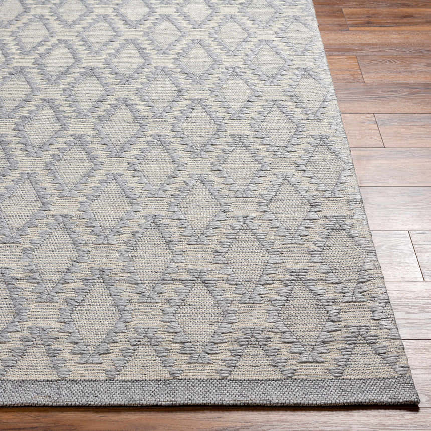 Close-up of the hand-woven Yank Area Rug. Dark gray geometric diamond pattern on a light gray background. Farmhouse style. Front