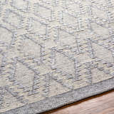 Close-up of the Yank Area Rug. Hand-woven rug with a geometric pattern in light and dark gray. Farmhouse style. Texture