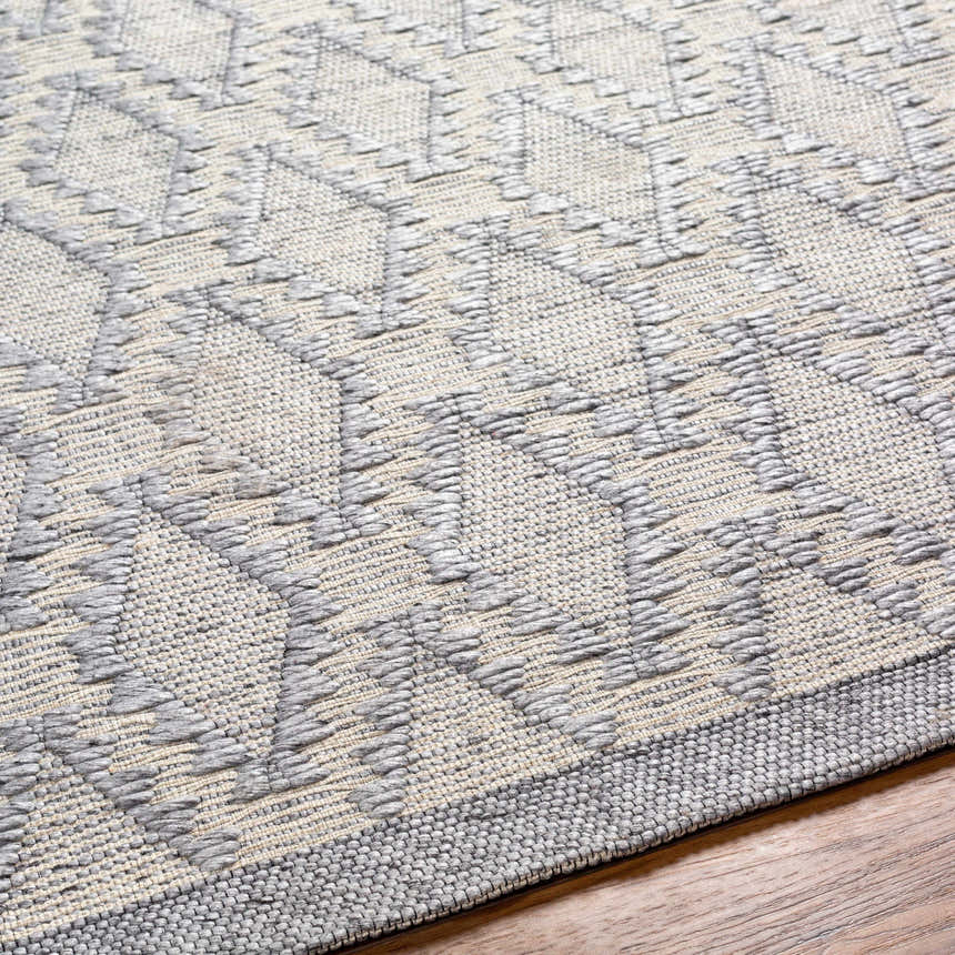 Close-up of the Yank Area Rug. Hand-woven rug with a geometric pattern in light and dark gray. Farmhouse style. Texture